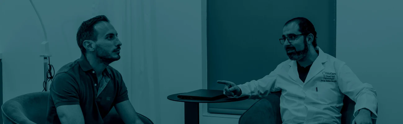 Teal-tinted photo of a patient and healthcare professional having a conversation during a consultation, used as a banner for the FAQ section.